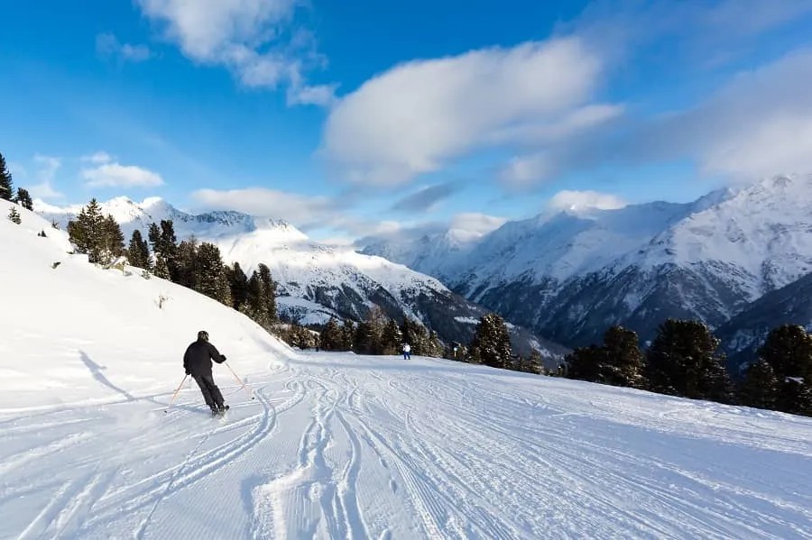 Skifahrer auf einer verschneiten Piste in den österreichischen Bergen